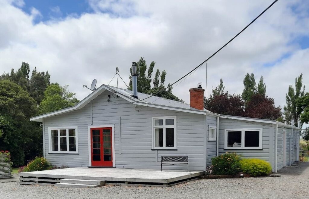 Professional exterior painting carried out on this project by the team of painters at Swish Decorating, with pewter grey walls of Resene Silver Chalice and showstopping spicy red doors in Resene Jalapeno.