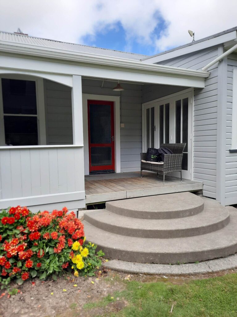 Professional exterior painting carried out on this project by the team of painters at Swish Decorating, with pewter grey walls of Resene Silver Chalice and showstopping spicy red doors in Resene Jalapeno.