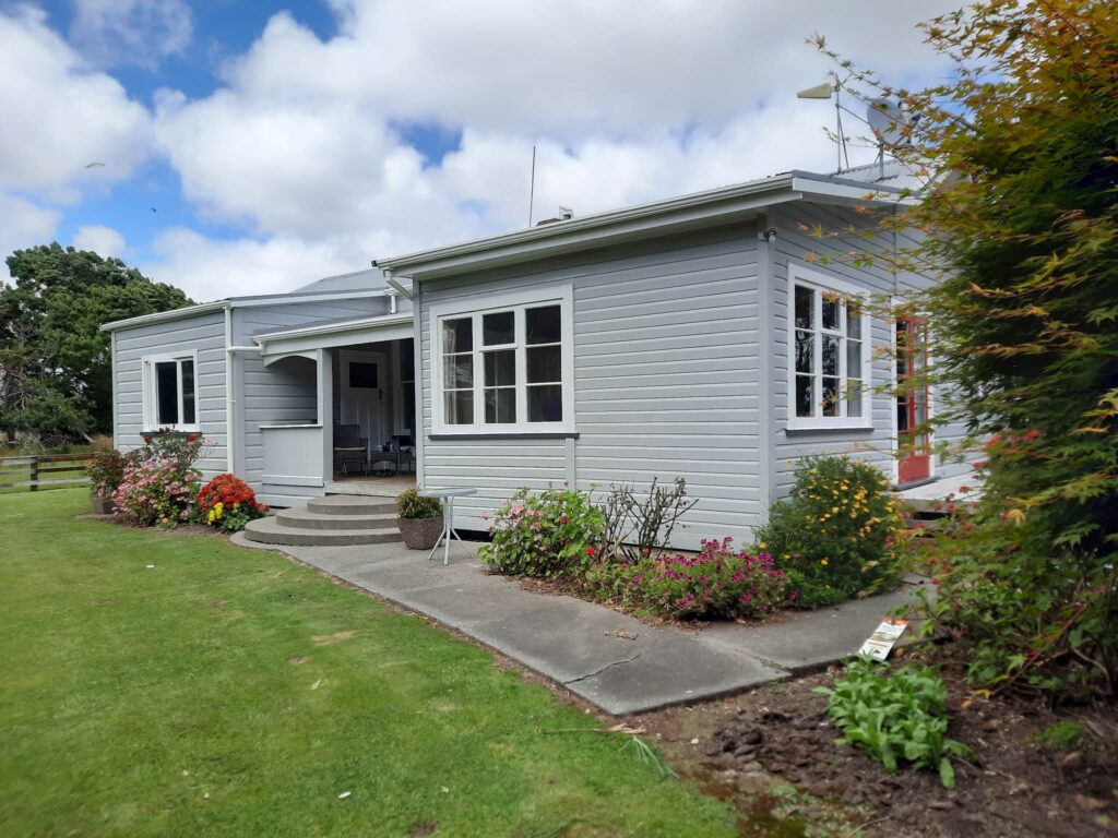 Professional exterior painting carried out on this project by the team of painters at Swish Decorating, with pewter grey walls of Resene Silver Chalice and showstopping spicy red doors in Resene Jalapeno.
