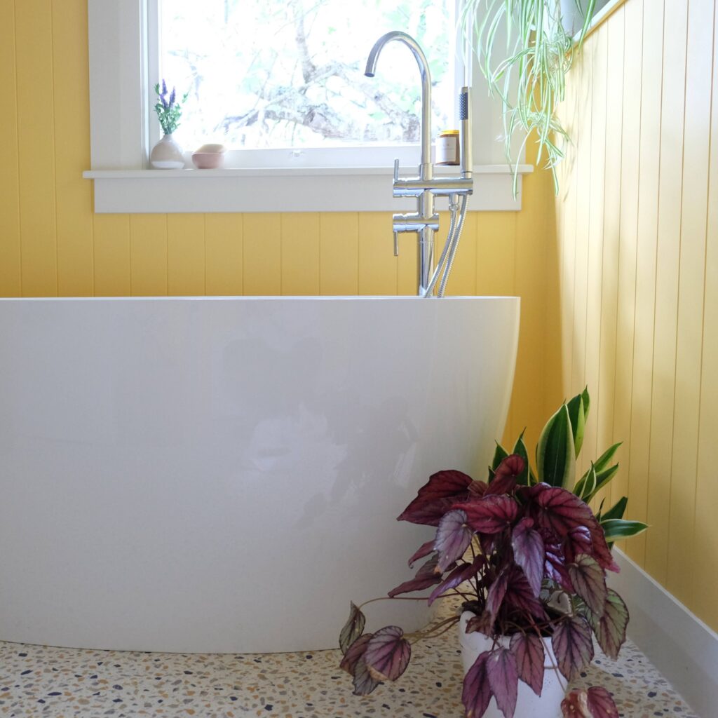 A stunning vibrant bold bathroom remodel with walls painted in the mellow yellow of Resene Cream Can in conjunction with Form Building