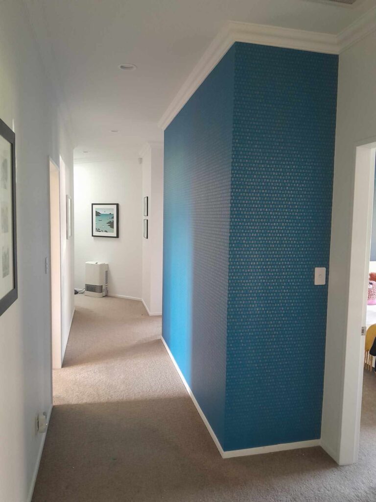 Blue and gold wallpaper feature wall in client's hallway hung by the professional wallpaper hangers at Swish Decorating