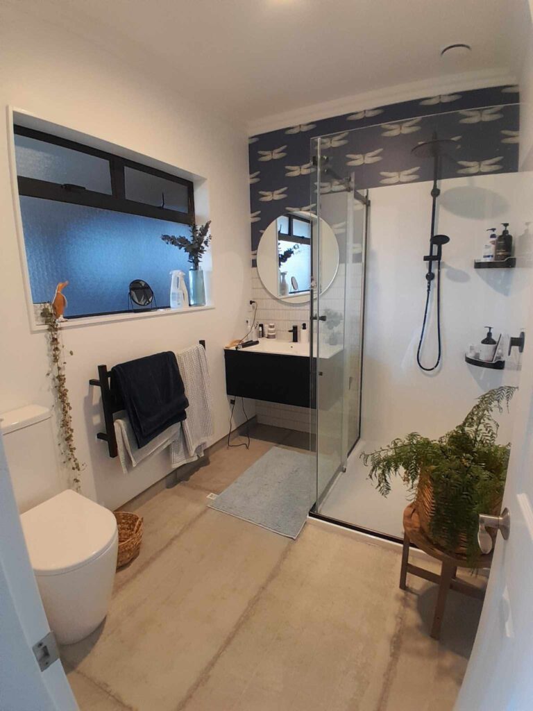 Bathroom walls painted in the near white of Resene Alabaster with a feature wall of dragonflies on a vinyl sticker