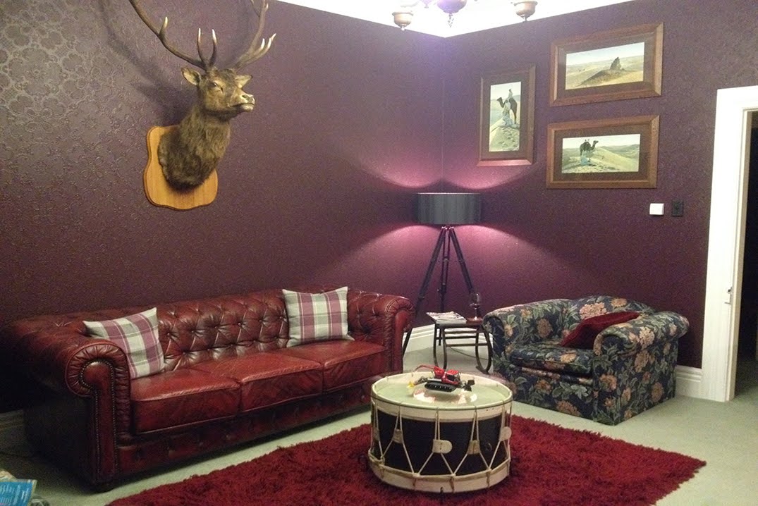 A dramatic deep red lounge with anaglyptic wallpaper providing texture