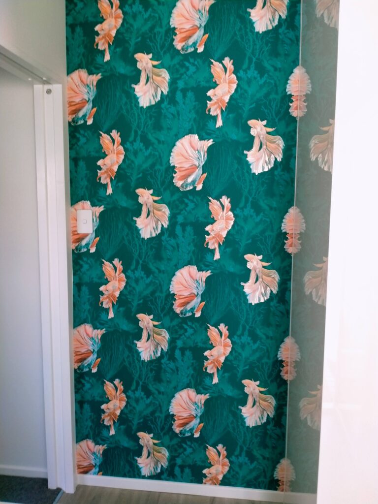 Goldfish wallpaper hung by the decorators at Swish Decorating creates a dramatic entrance to this laundry room