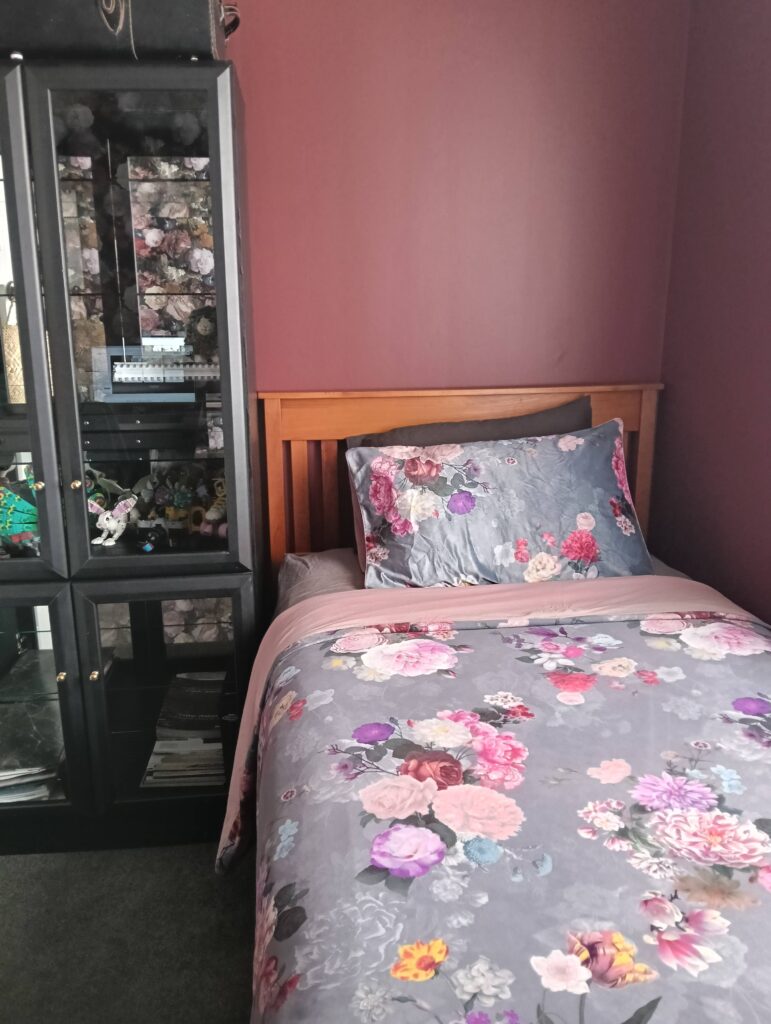 The deep earthy red of Resene Avant Garde provides a dramatic backdrop to this bedroom and office space