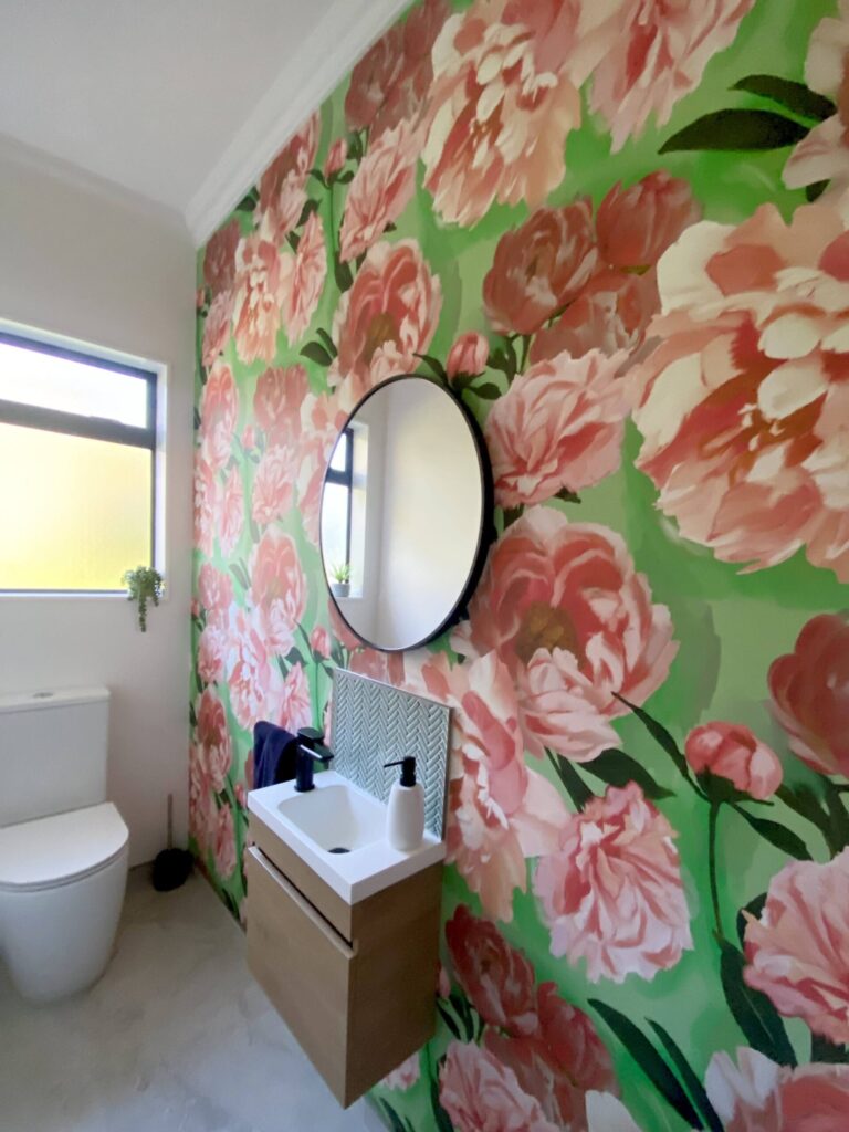 Vibrant floral feature wallpaper hung by the decorators at Swish Decorating in a client's bathroom creating a sense of drama